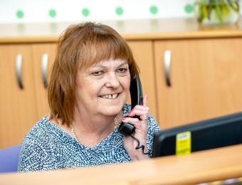 Smiling Receptionist answering the phone at Reception