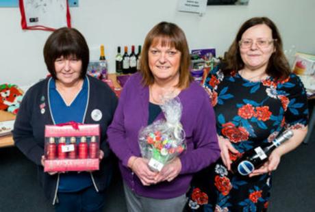 3 people holding donated items