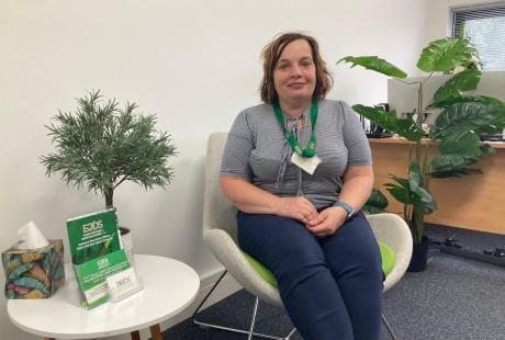 Paula from EoDs sat smiling in a chair in her new office.