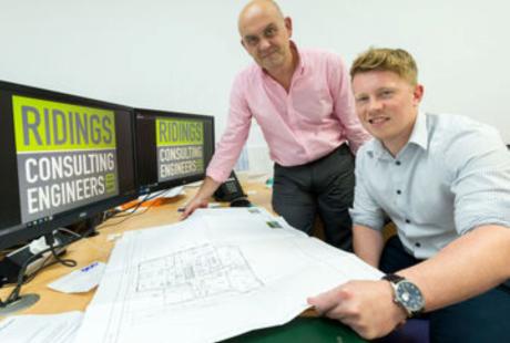 2 members of the company in front of a computer screen