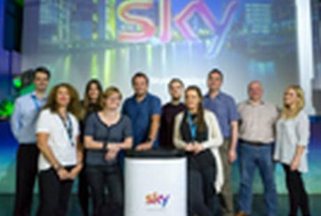 Members of Sky team stood around a podium